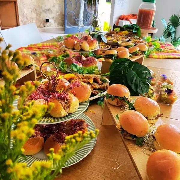 Buffet de mini burgers et bouchées créoles sur une nappe en madras